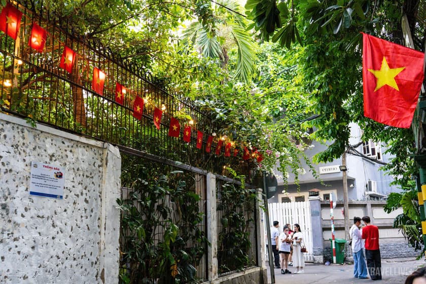 The alley under a canopy of red flags leading to ngâm CAFE