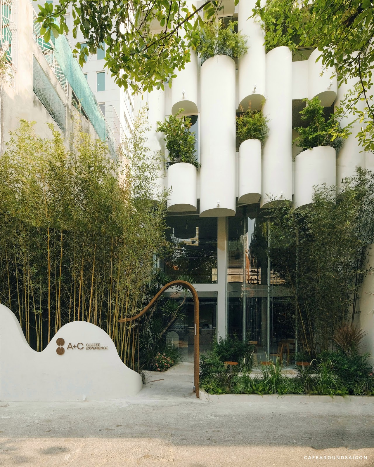 The white cylindrical planter facade with bamboo