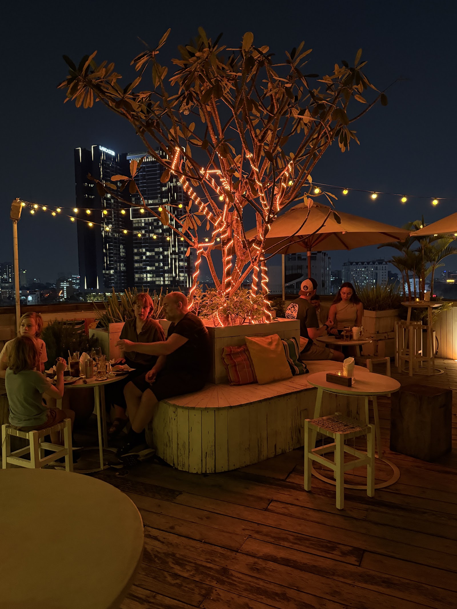 The rooftop at night under neon-gold light