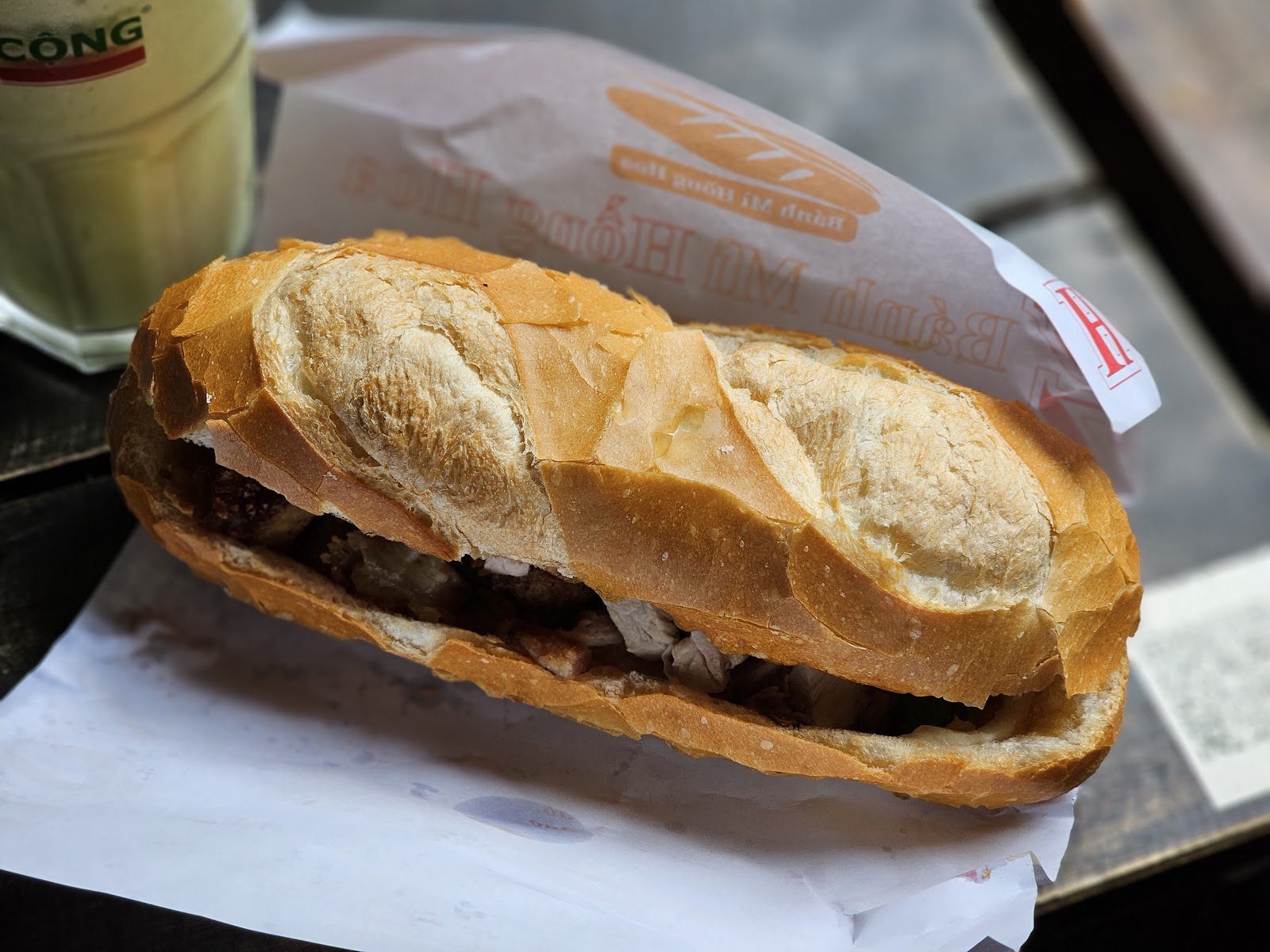 Whole Hồng Hoa bánh mì in the shop's paper wrap