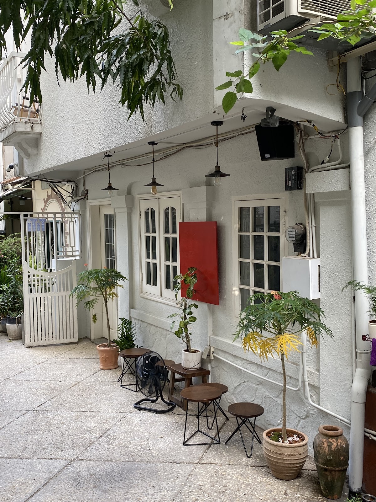 Sân vườn Café Mô-tê ban ngày: cây xanh và tủ sắt đỏ