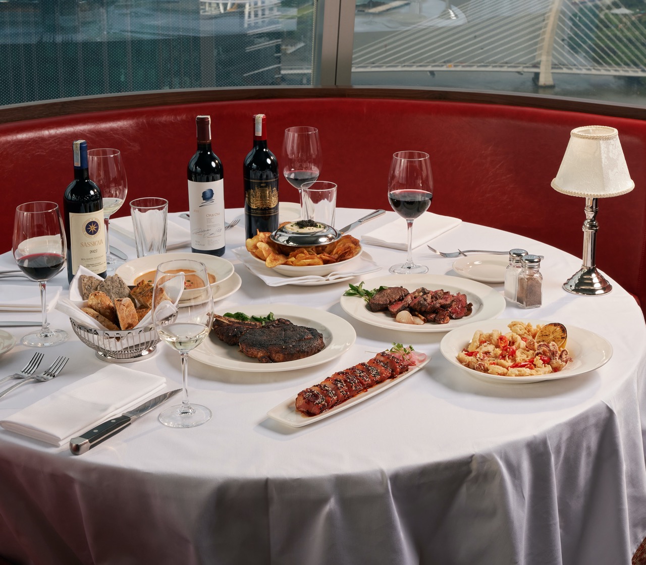 Table spread with steaks, shrimp and wine