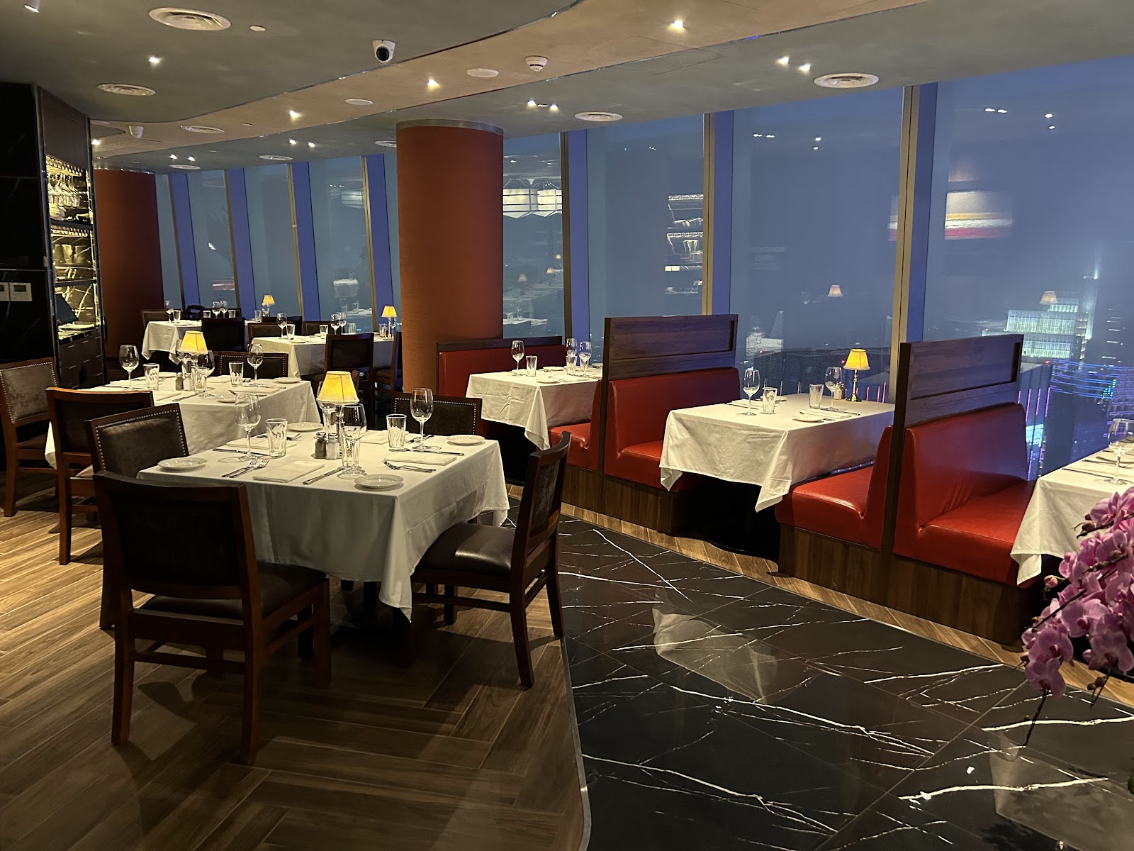 The Capital Grille dining room at dusk, overlooking the city lights