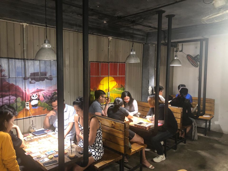 Khu chơi — bàn game dưới tranh tường panda