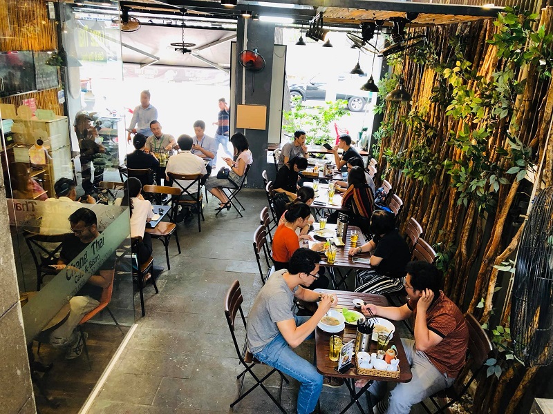 Inside Chang Thai Cafe&Bistro: diners at wooden tables, bamboo wall, daylight from the street