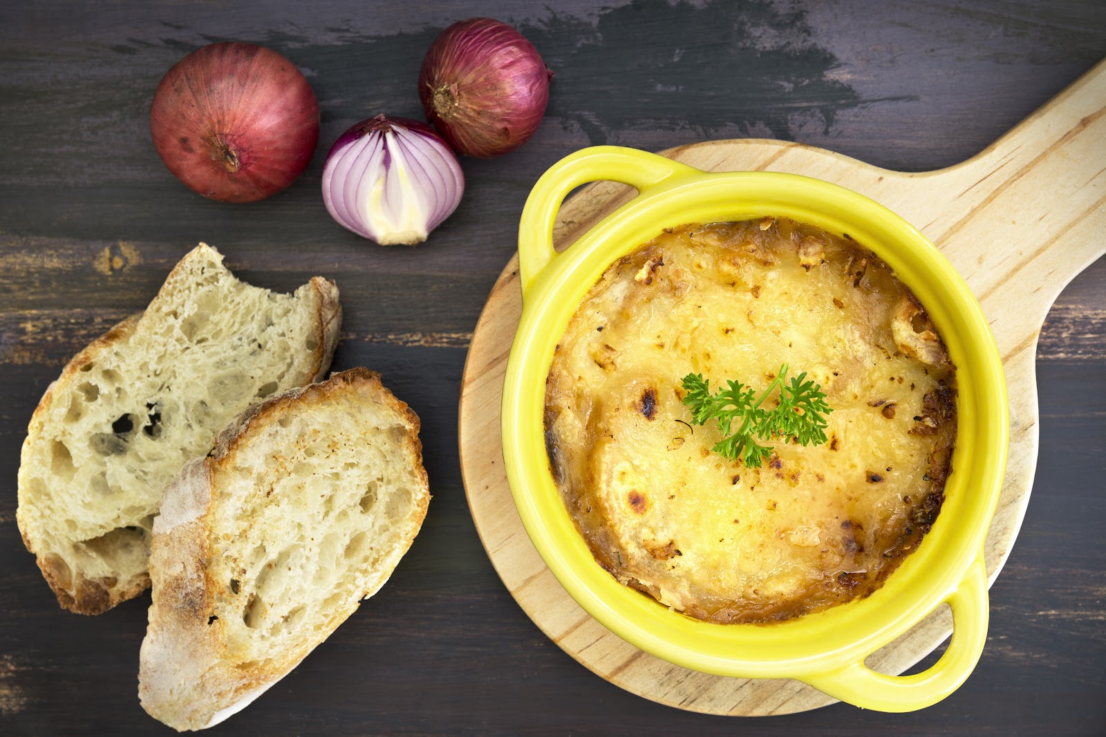 Súp hành Pháp với lớp phô mai gratine, phục vụ trong nồi cocotte vàng, kèm bánh mì và hành đỏ