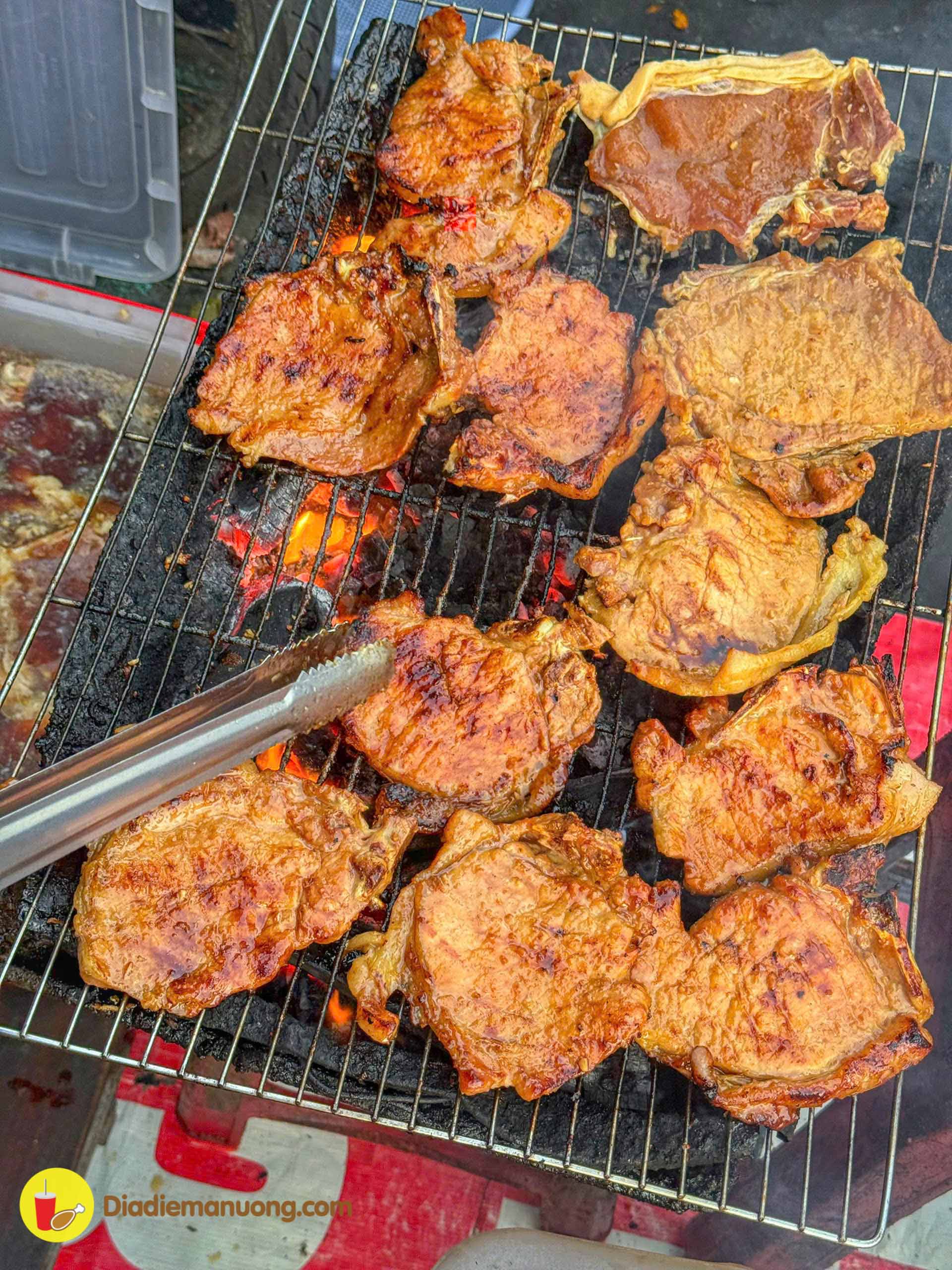 Ribs grilling over red charcoal at the Com Tam Co Giang stall