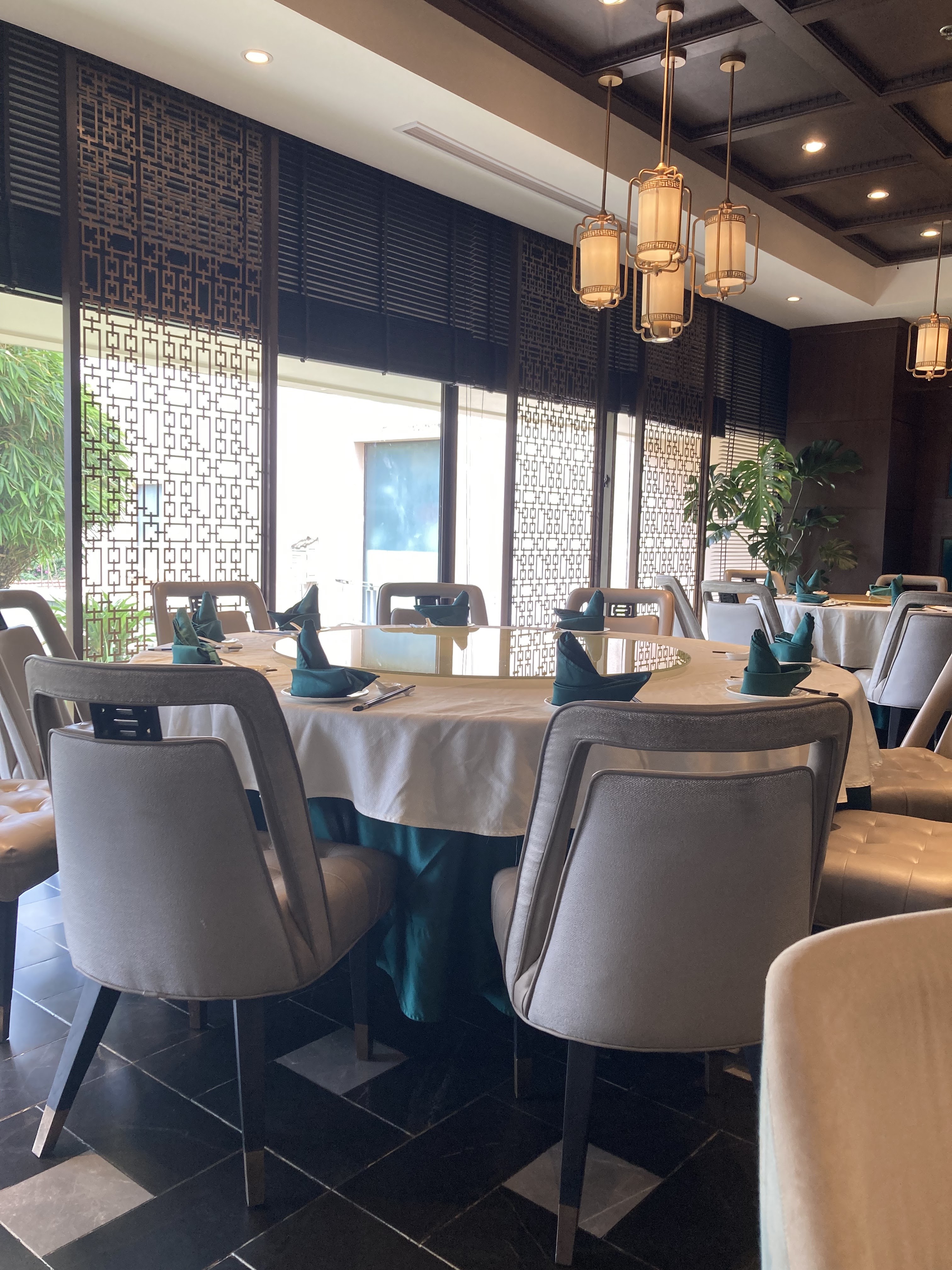 Window-side tables: gold lattice screens, brass lanterns, bamboo beyond