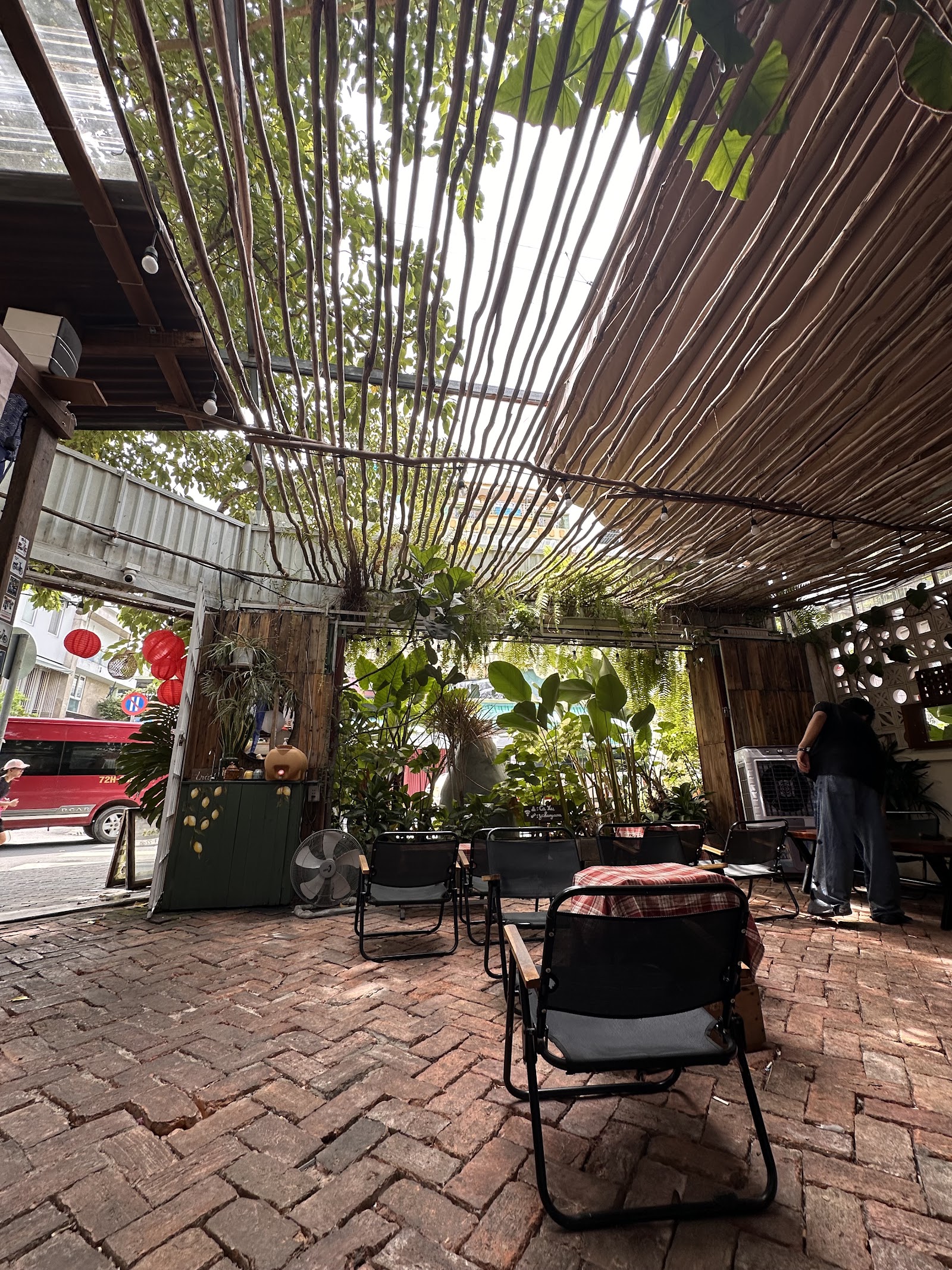 The daytime patio — vine pergola, red brick, red lanterns
