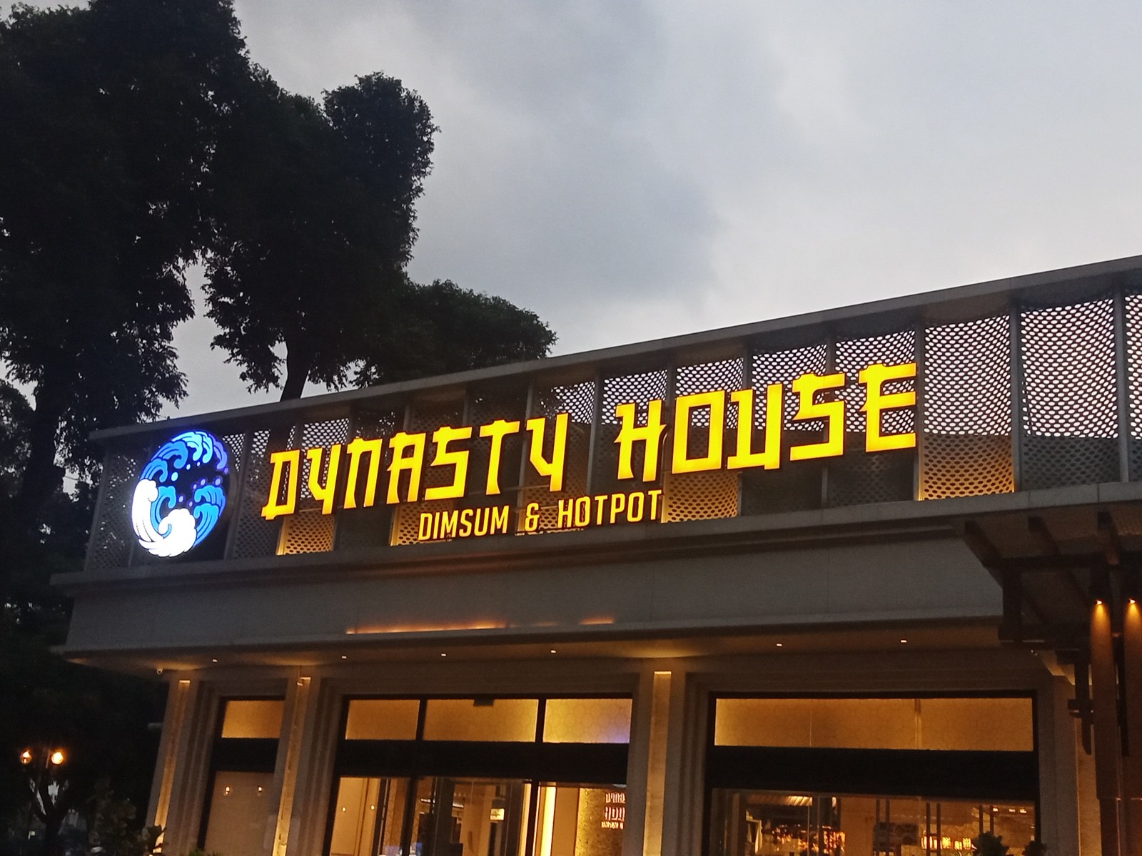 The glowing gold DYNASTY HOUSE sign at dusk