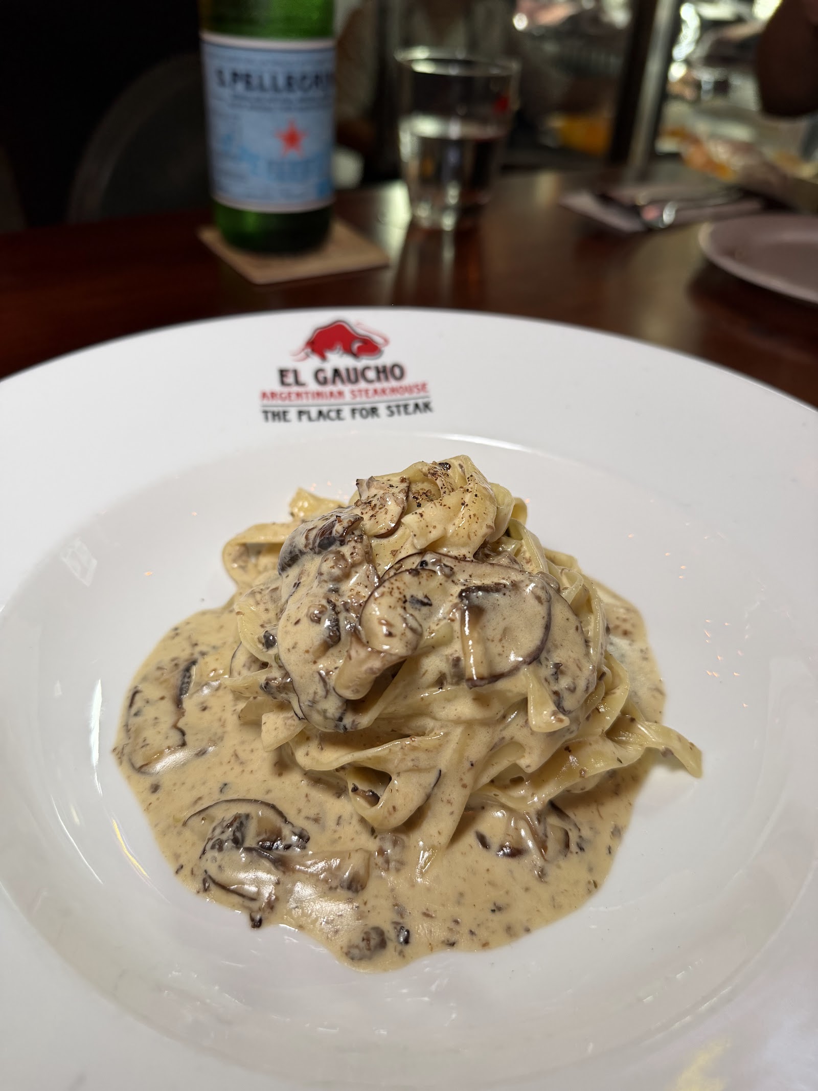 Creamy mushroom pasta on the branded El Gaucho plate