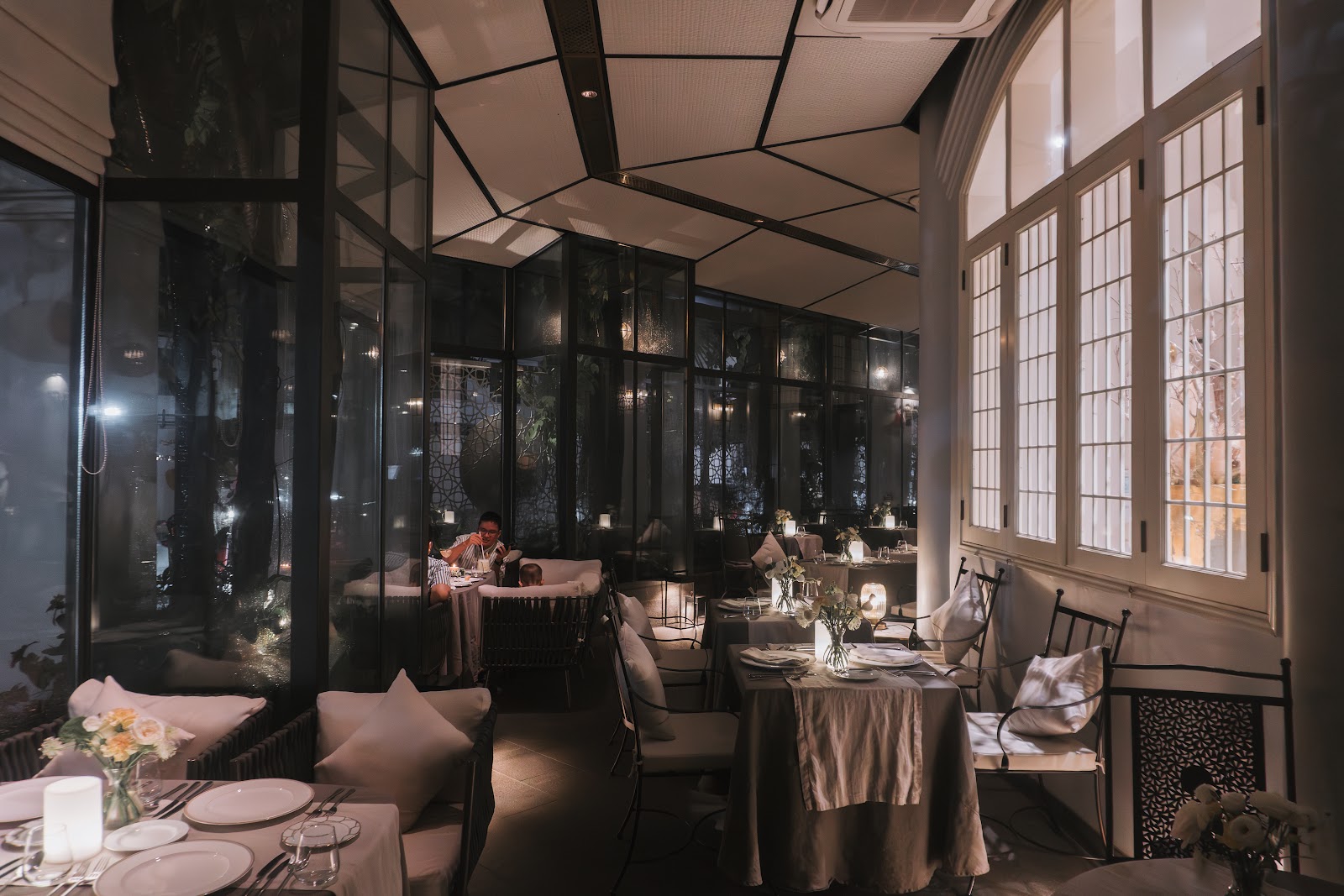 The glasshouse dining room at night, guests at dinner
