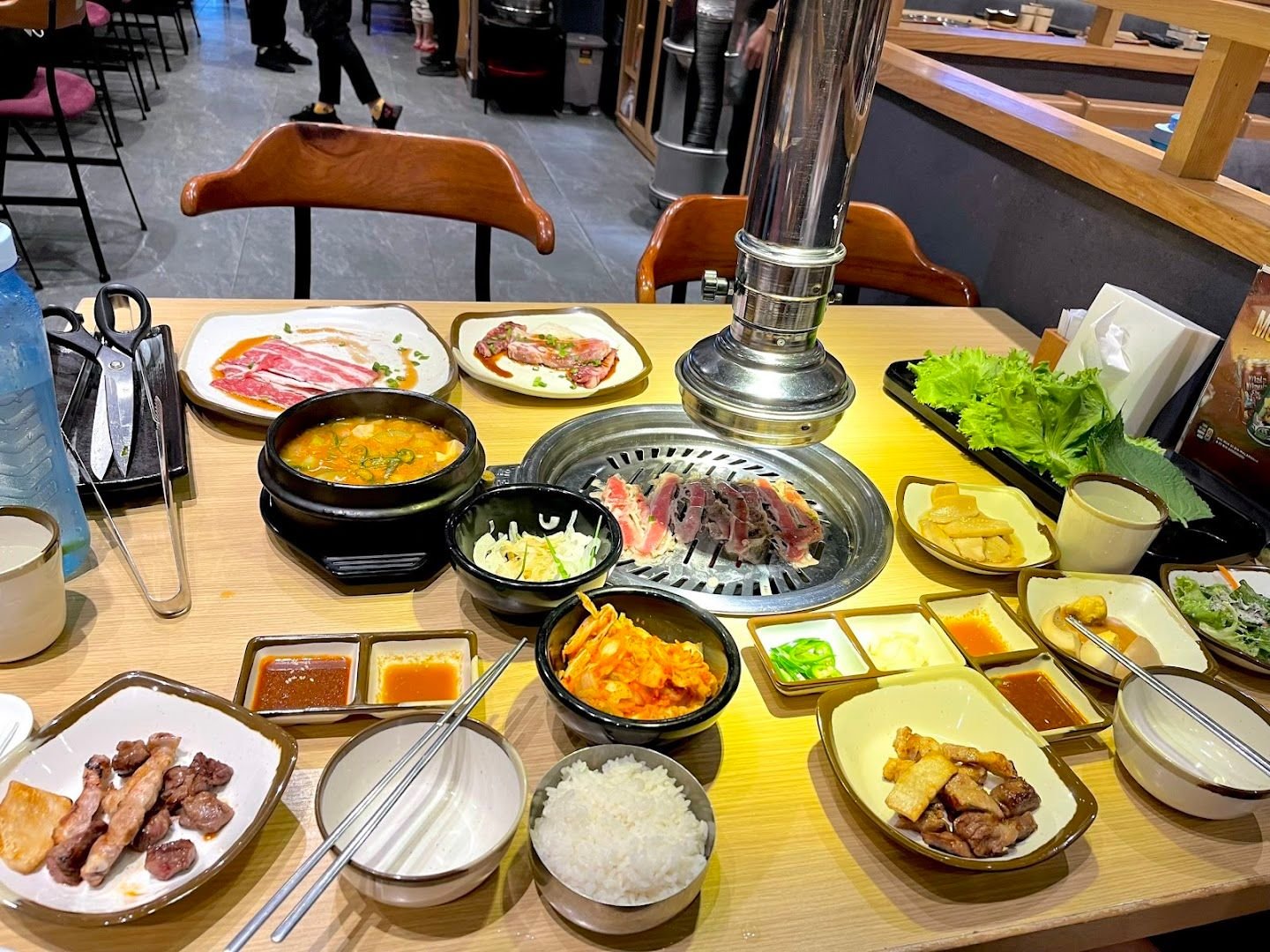 Bàn ăn thật của thực khách: vỉ nướng, panchan, canh, cơm, kéo cắt thịt
