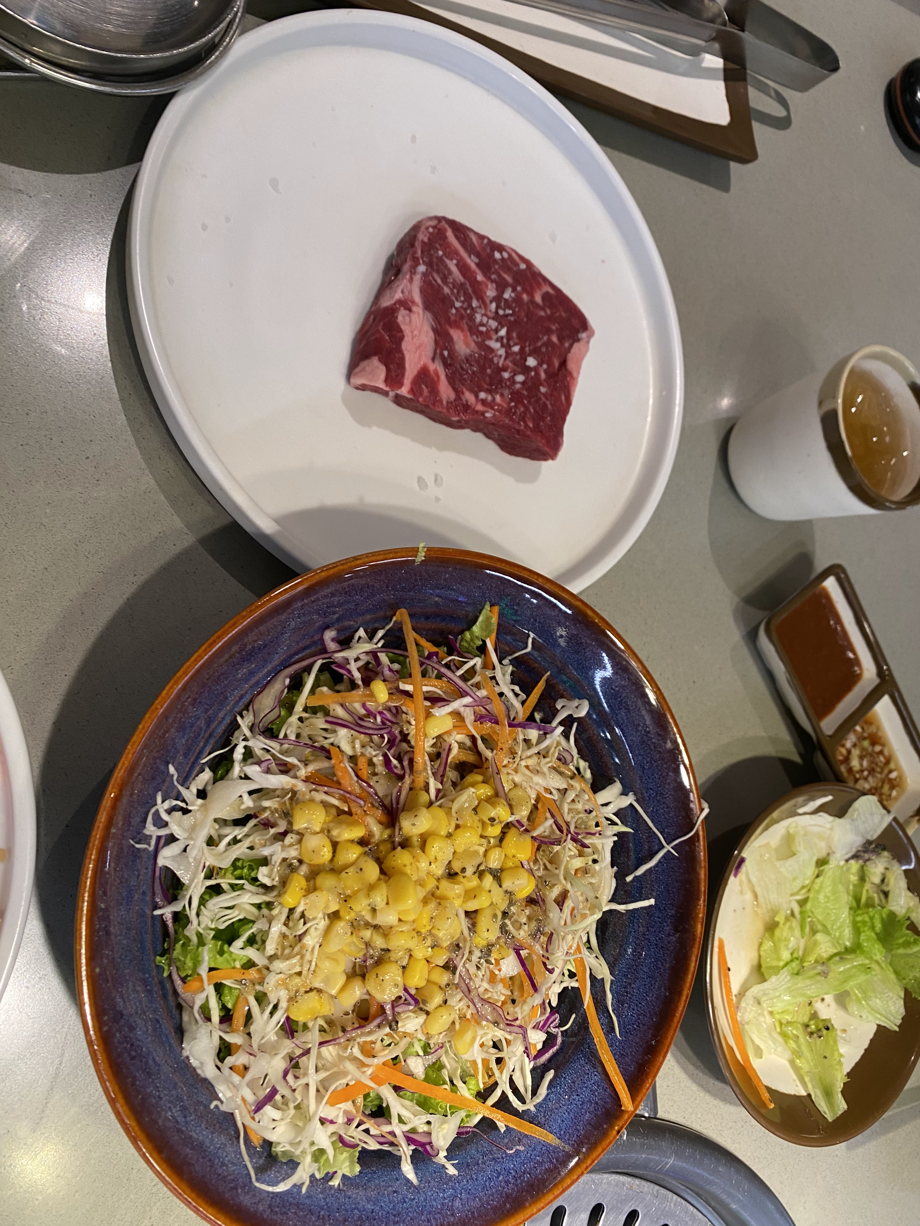 GoGi House Vincom Dong Khoi — marbled US beef grilling on the tabletop grill (Kim Bich, 09/2026)