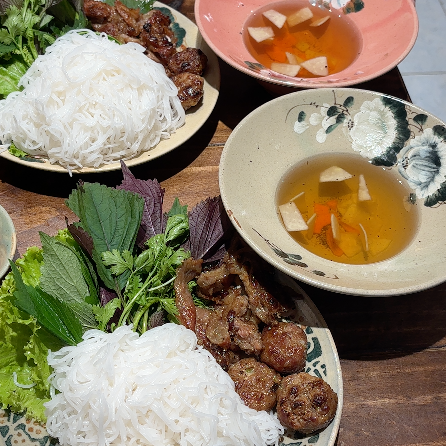 Hai bát bún chả với nước chấm vàng óng và thịt viên nướng
