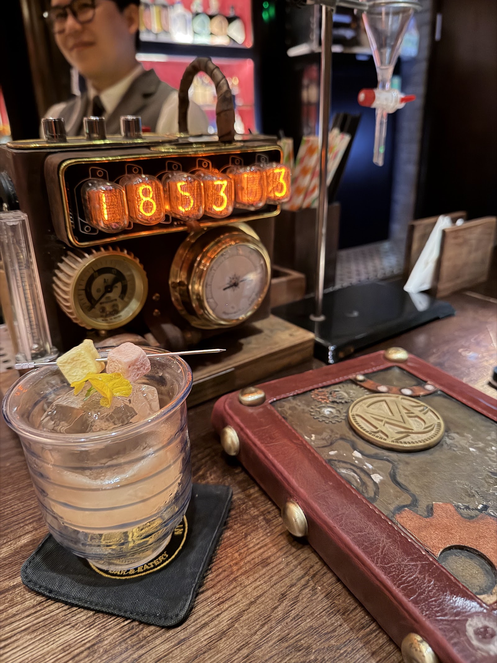 Quầy giả kim — đồng hồ ống nixie, đồng hồ đo áp suất, một ly signature