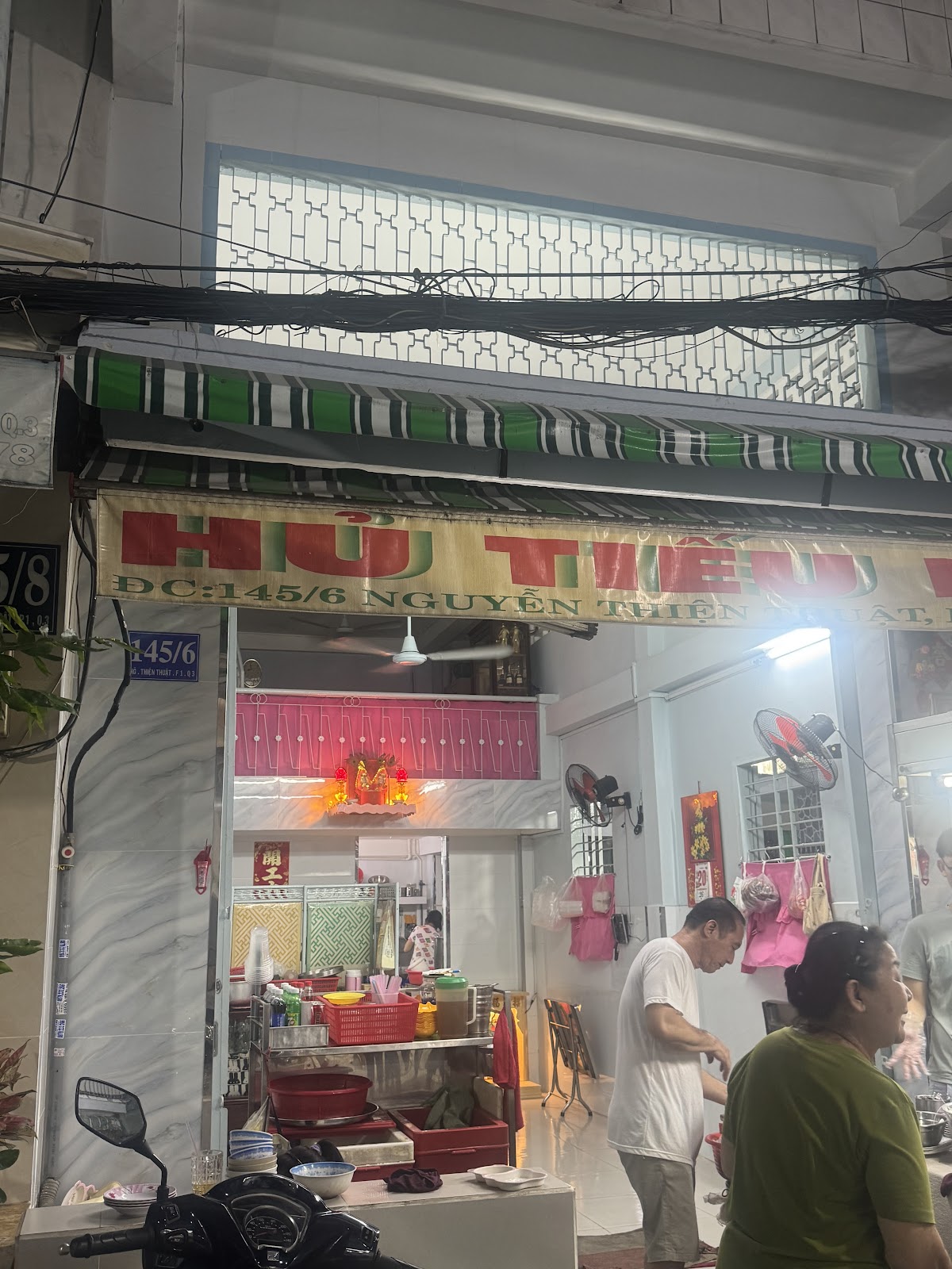Mặt tiền Trường Thạnh ban đêm — bảng hiệu HỦ TIẾU và mái hiên sọc xanh trắng