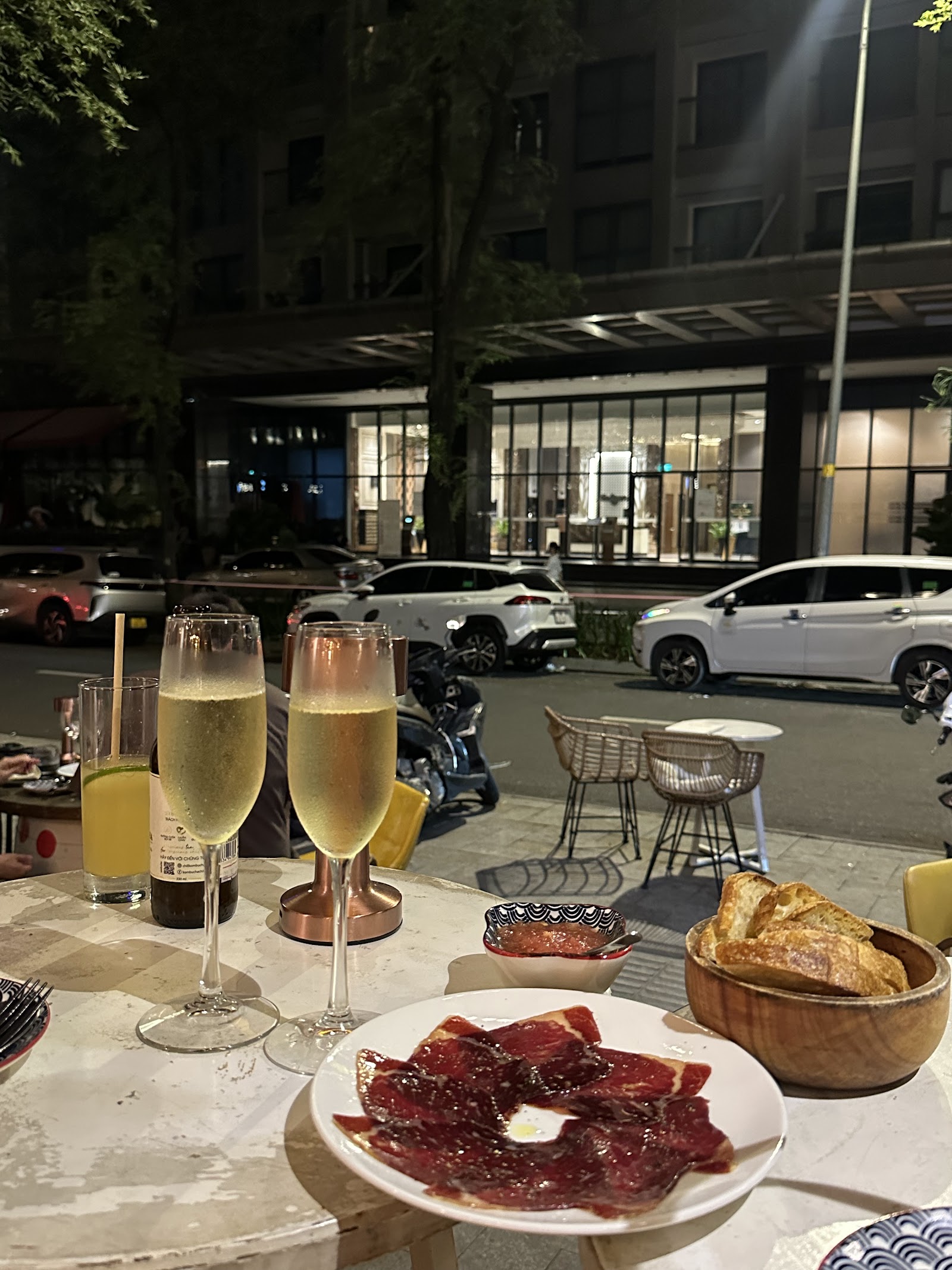 Jamón, bread and sparkling wine on the terrace table at night