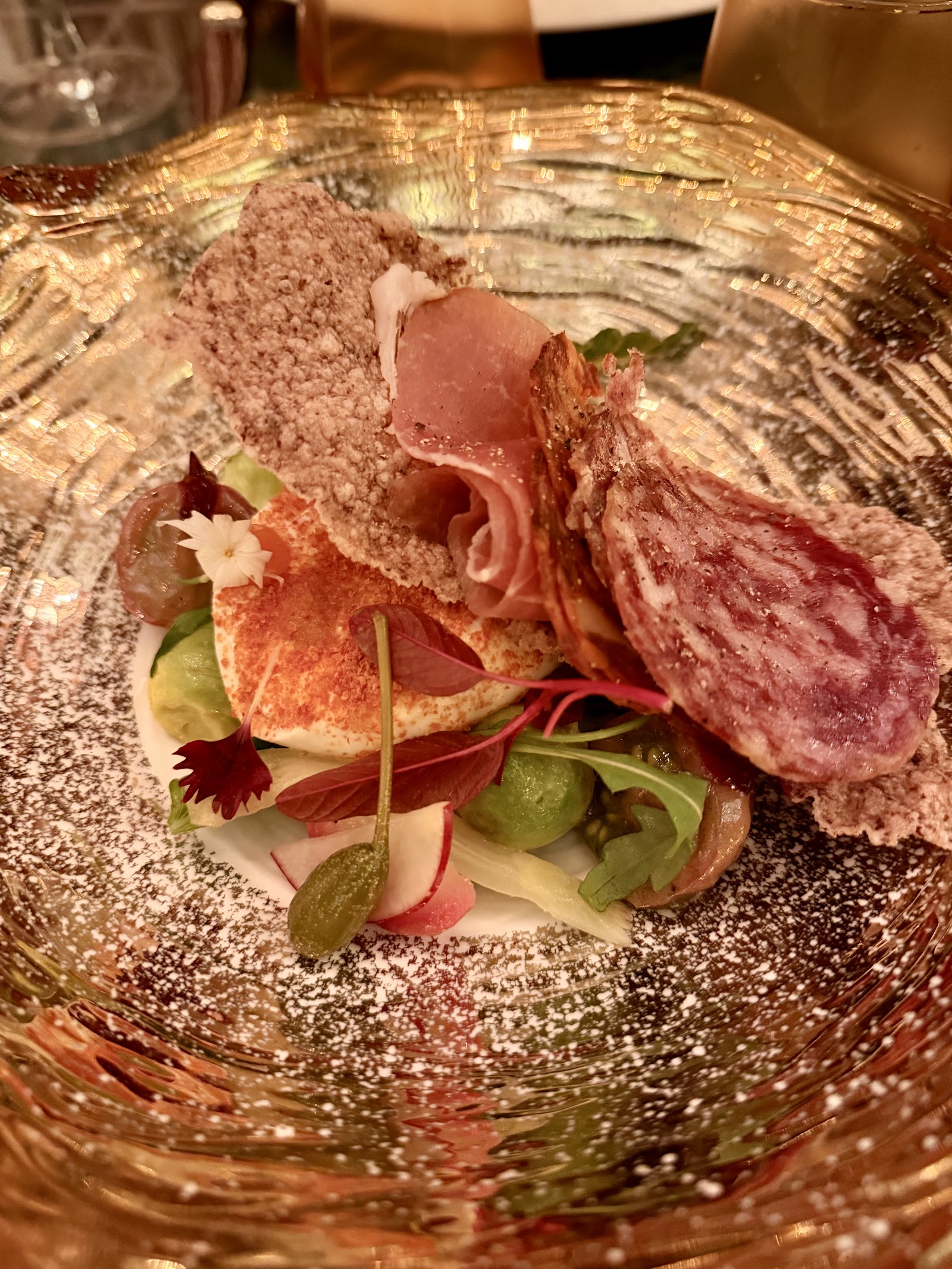 Charcuterie and cheese plate with grapes and greens
