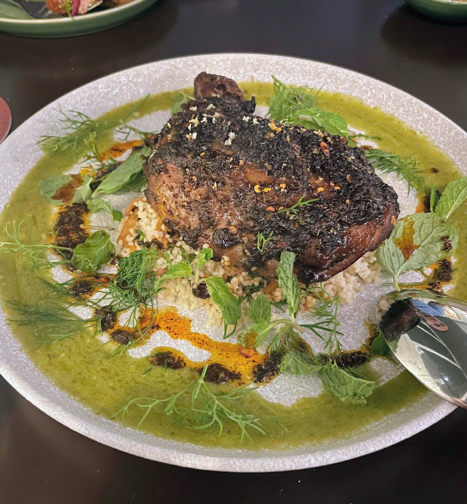 Sườn cừu tẩm gia vị nướng trên couscous với rau thơm