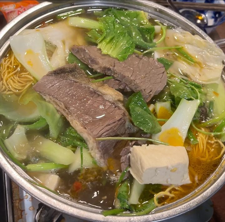 Thịt bò thái lát, tàu hũ và mì trong nồi lẩu tại Lẩu Bò Nhà Gỗ