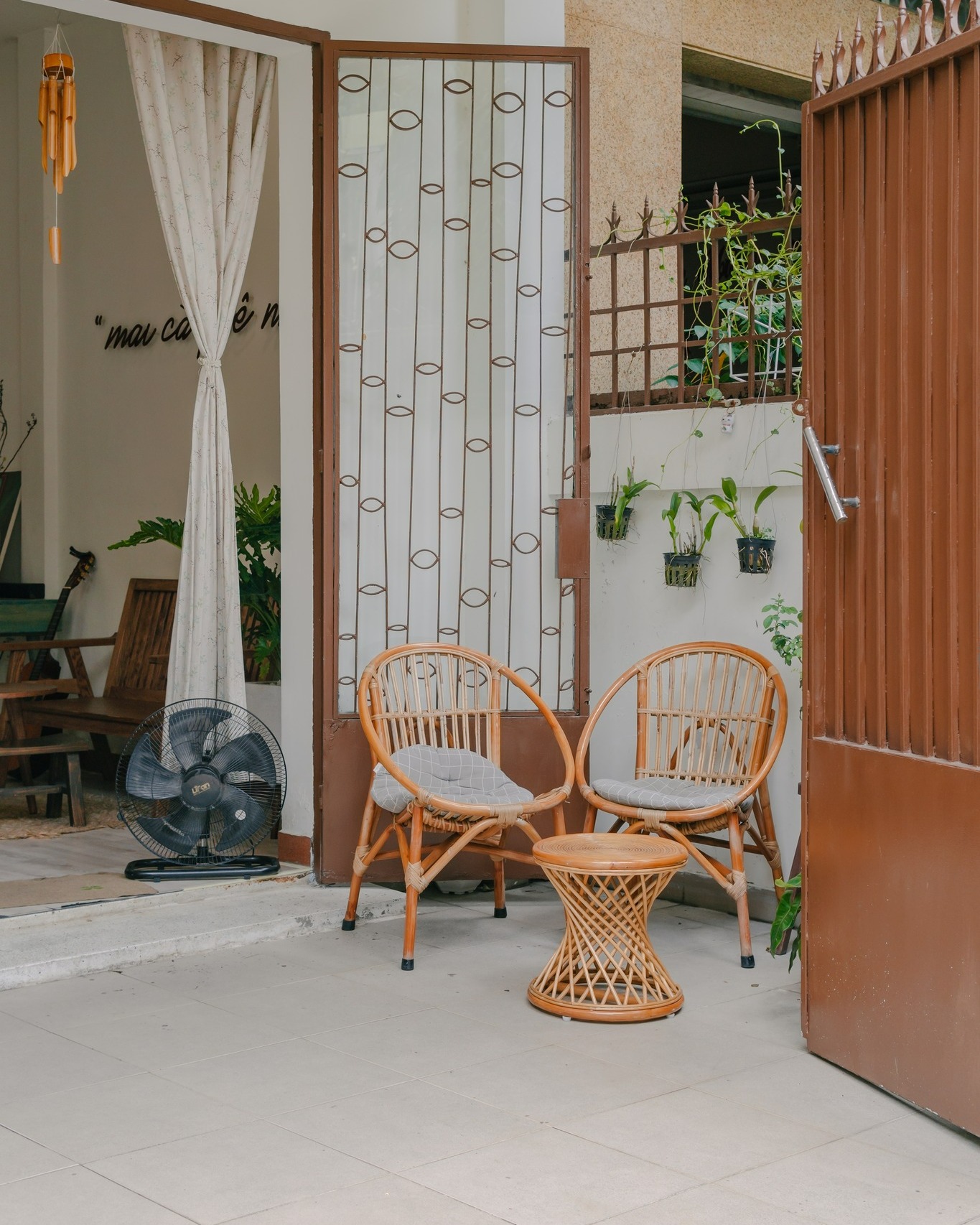 Sân trước với ghế mây và cổng sắt nâu