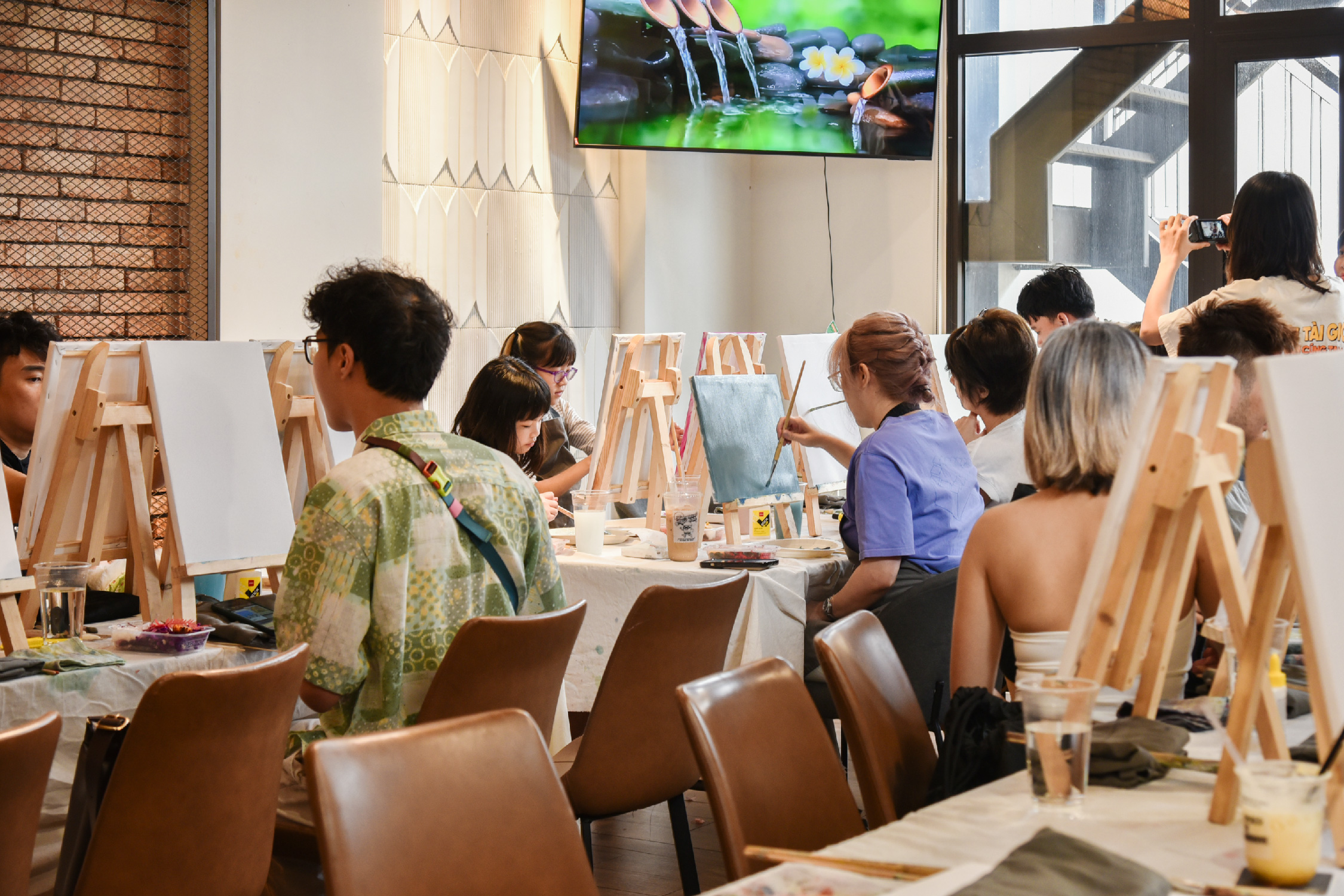 The painting workshop at easels, with brick and 3D leaf walls