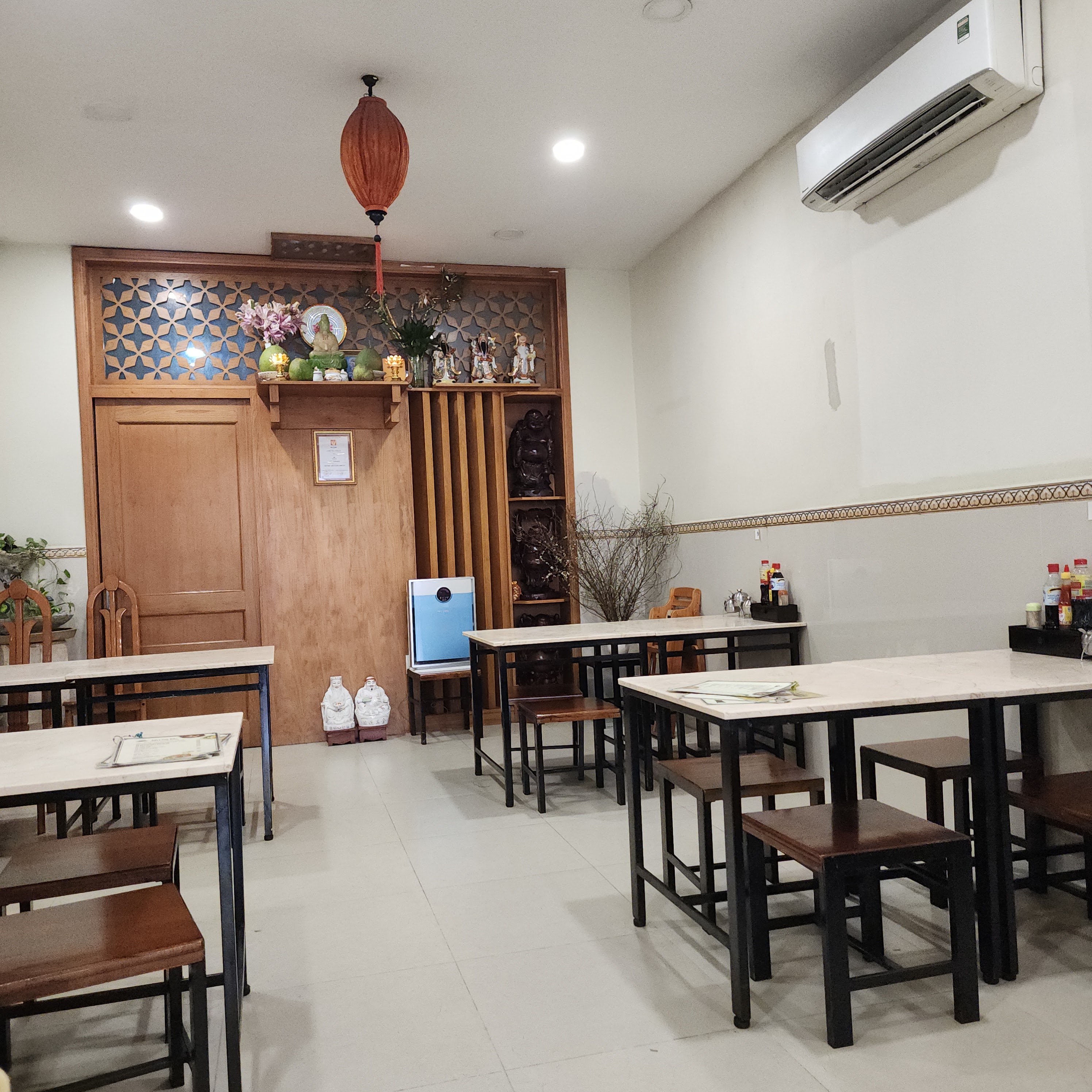 Góc quán Mì Chú Tắc ban ngày — bàn ghế gỗ và vách lam