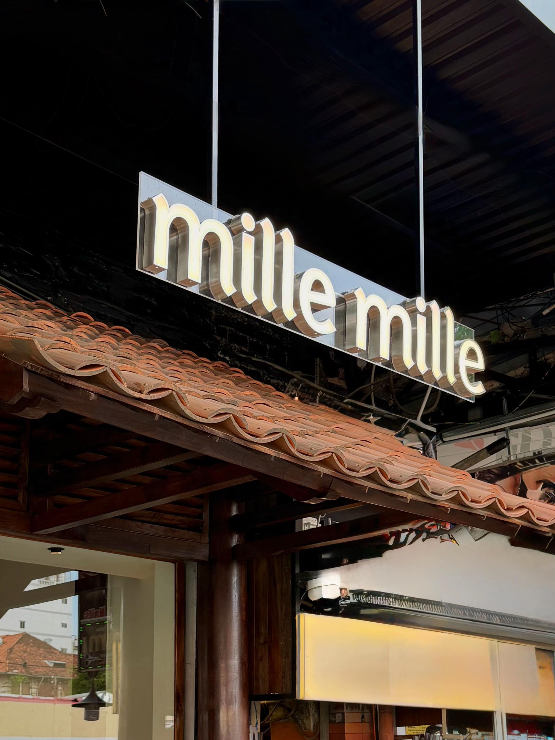 Mille Mille Ben Thanh — the illuminated sign glowing above the awning at night