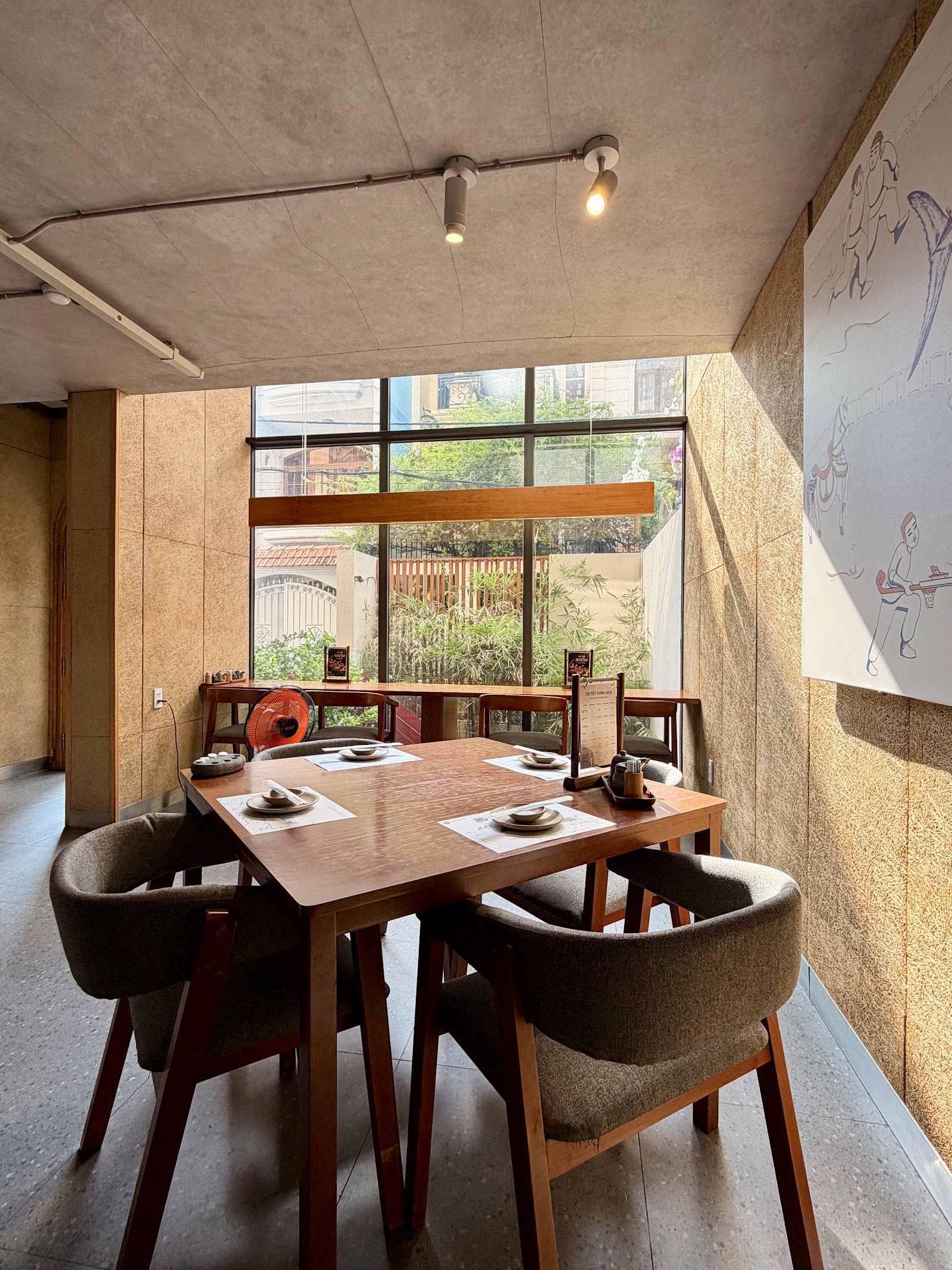 Window-side tables: raw straw-textured walls, wood tables, the tuna mural