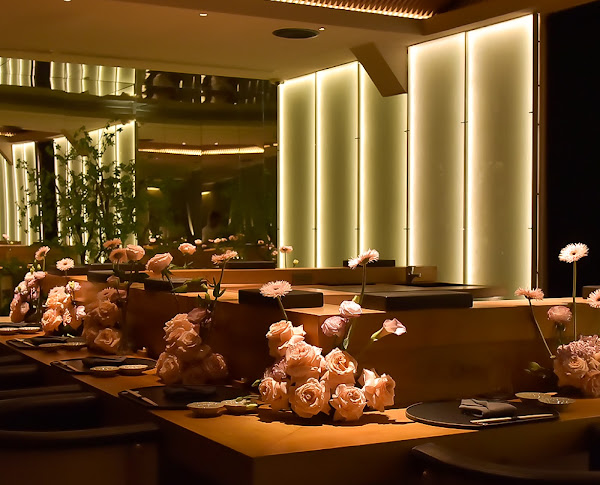 Quầy omakase NORIBOI với hoa và ánh đèn ấm