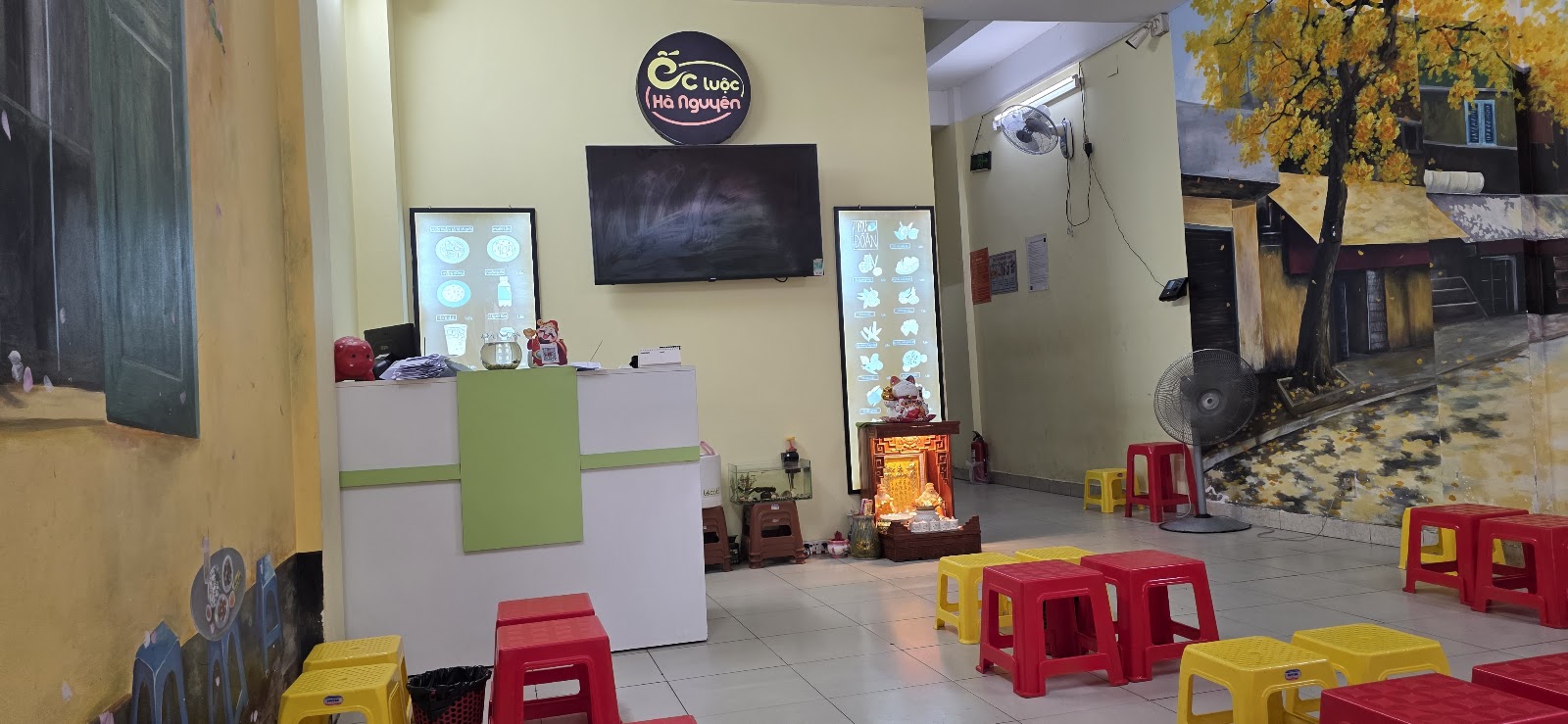 Không gian quán Ốc Luộc Hà Nguyên — tranh tường, ghế đẩu, quầy thu ngân