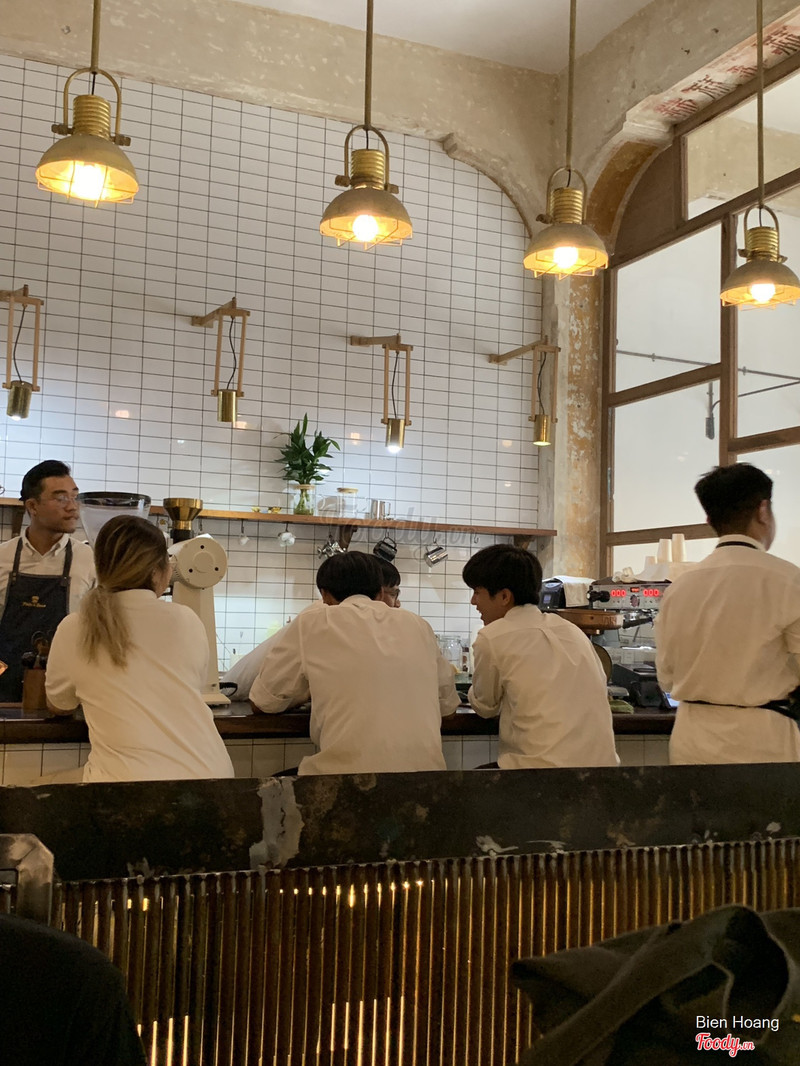 Quầy bar đông khách dưới hàng đèn đồng