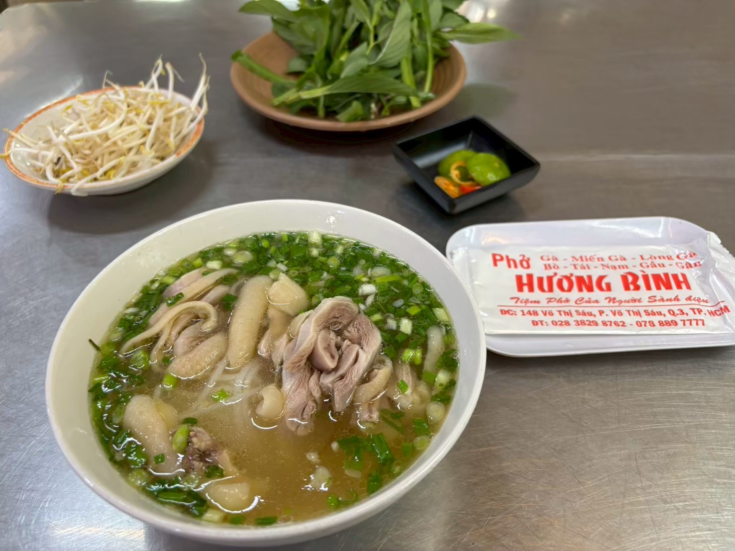The Huong Binh chicken-pho bowl — clear broth, firm chicken