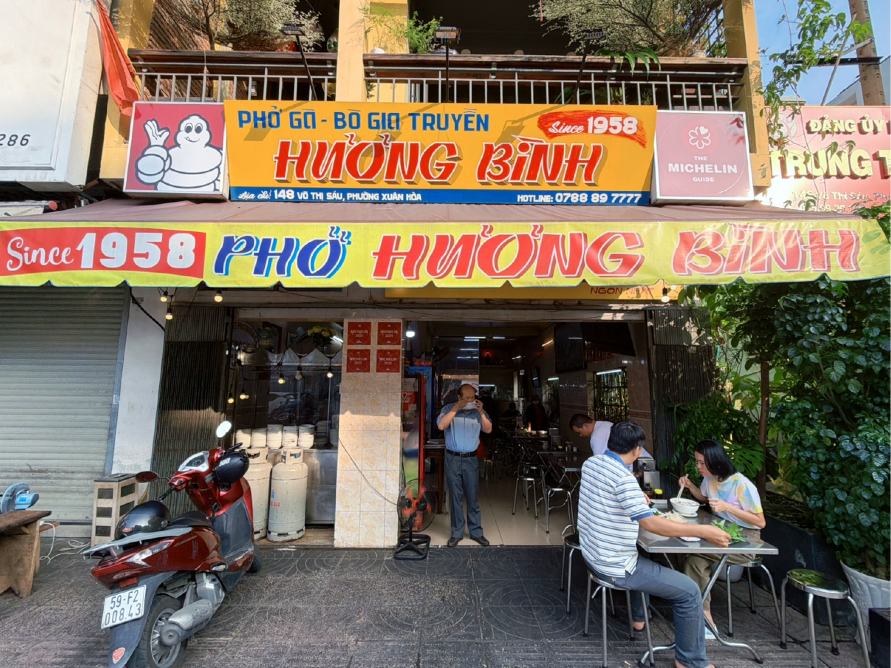 The Pho Huong Binh storefront — the yellow signboard with red letters