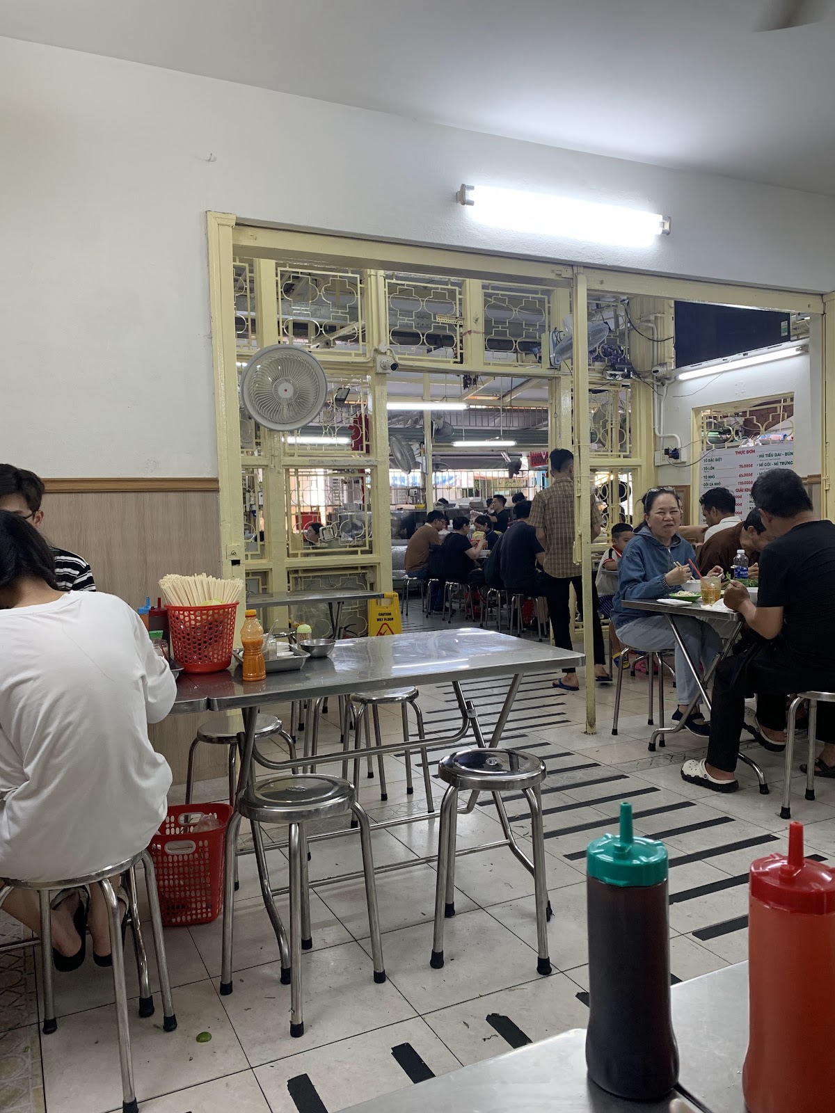 Tô phở gà trên bàn inox, đĩa rau thơm