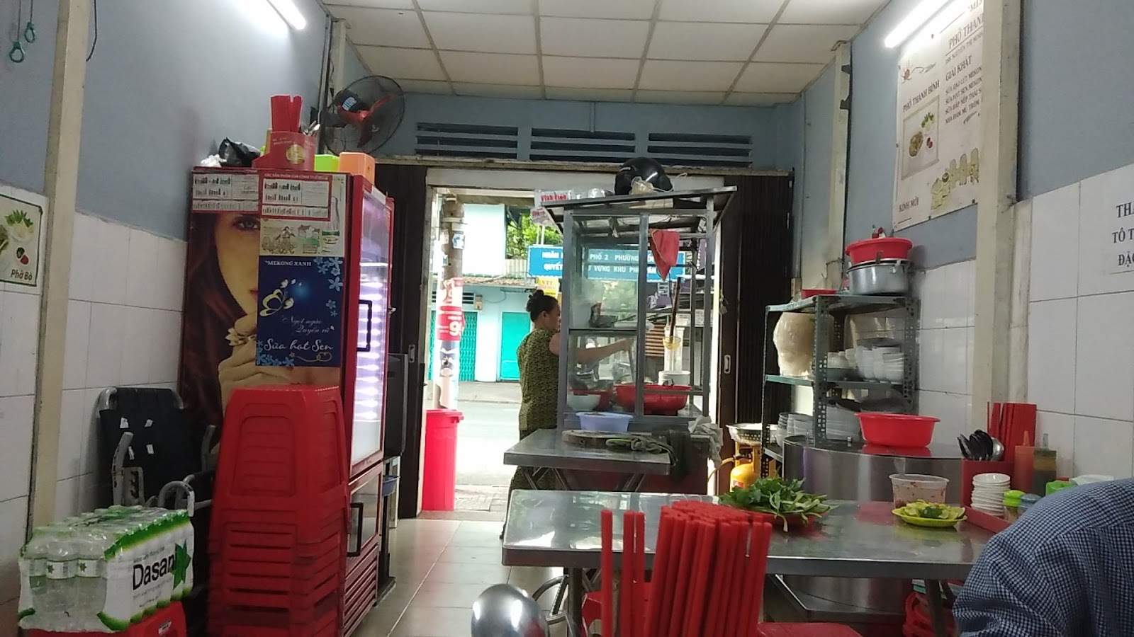 Không gian ca tối — ghế nhựa đỏ quanh bàn inox dưới đèn tuýp