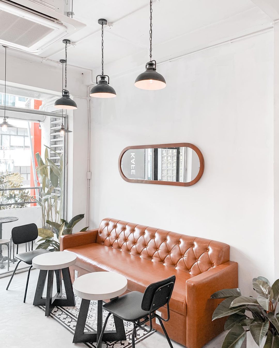 Gương tròn và sofa da caramel