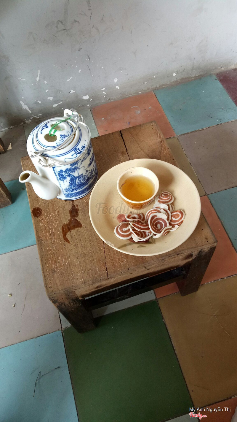 Ấm trà, tách trà và bánh tai heo trên ghế gỗ