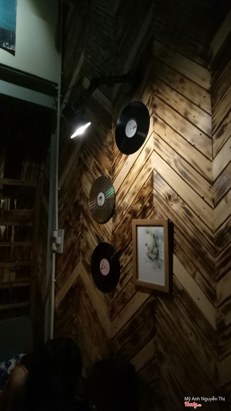 Đĩa than và CD treo trên tường gỗ đốt cháy zigzag