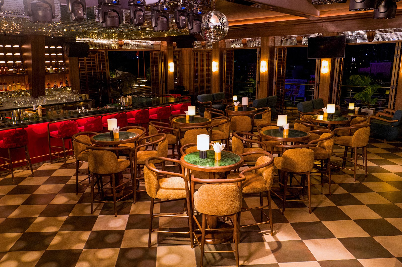 Quầy bar trong nhà với đèn đồng và ghế nhung đỏ
