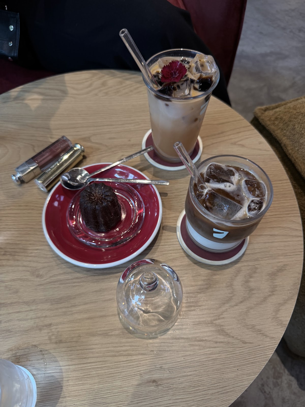 Sancara Caffe — cà phê đá và bánh canelé trên đĩa đỏ
