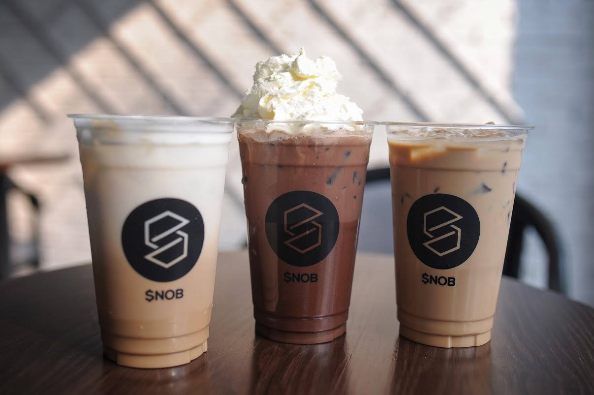S 로고가 새겨진 Snob Coffee 컵 세 개