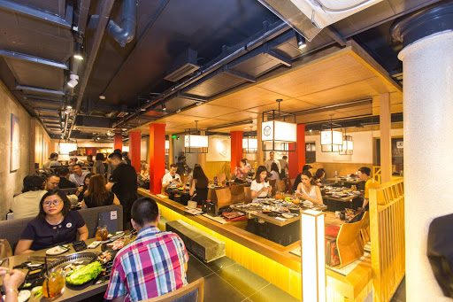 Warm dining hall with red pillars and tabletop grills