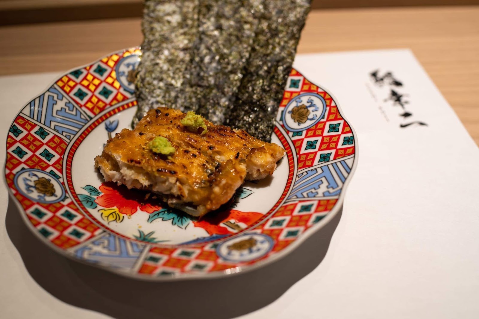 Grilled fish with nori on a patterned plate, the 鮨幸二 calligraphy menu