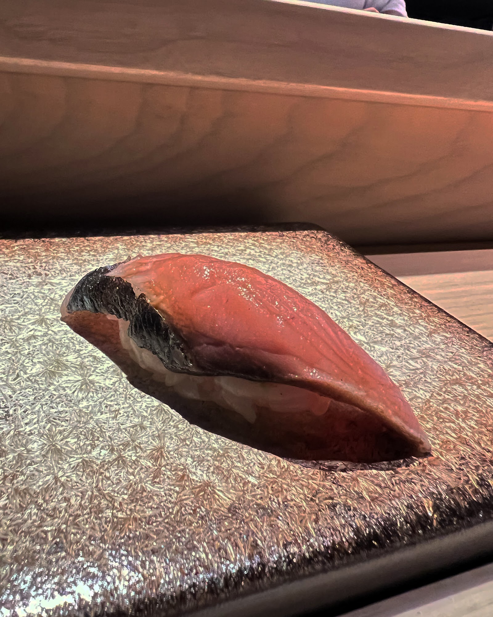 Tuna nigiri on a stone plate under the spotlight