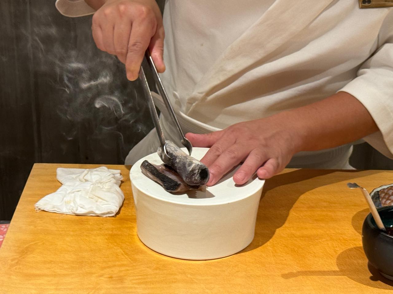 Bàn tay đầu bếp hoàn thiện món cá trên khói than binchotan