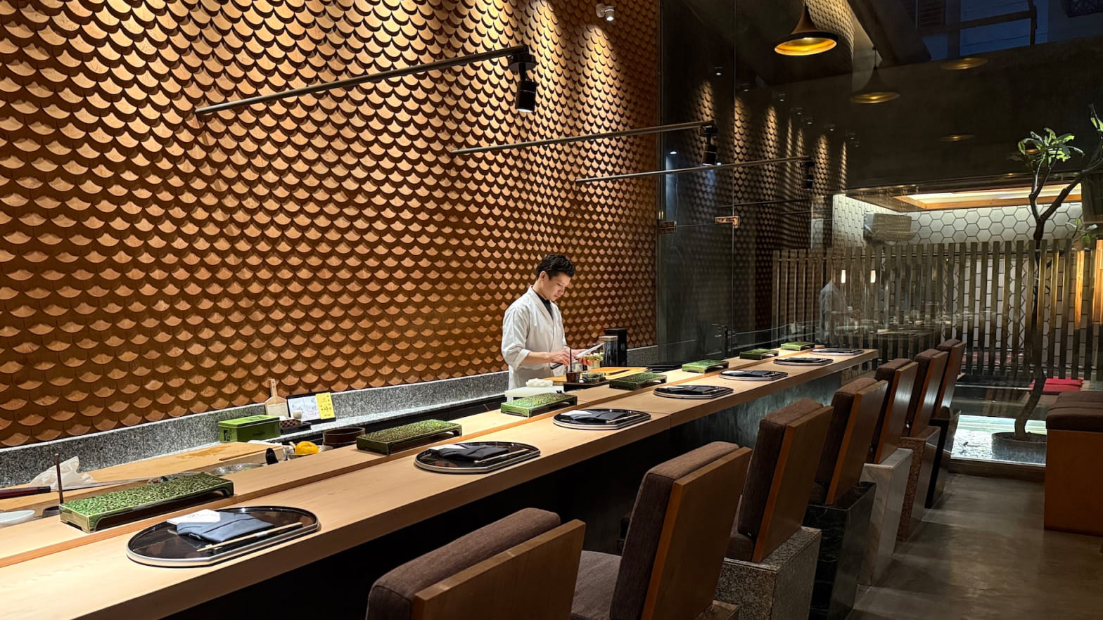 Quầy hinoki 8 ghế của Sushi Rei với bức tường vảy sò gỗ