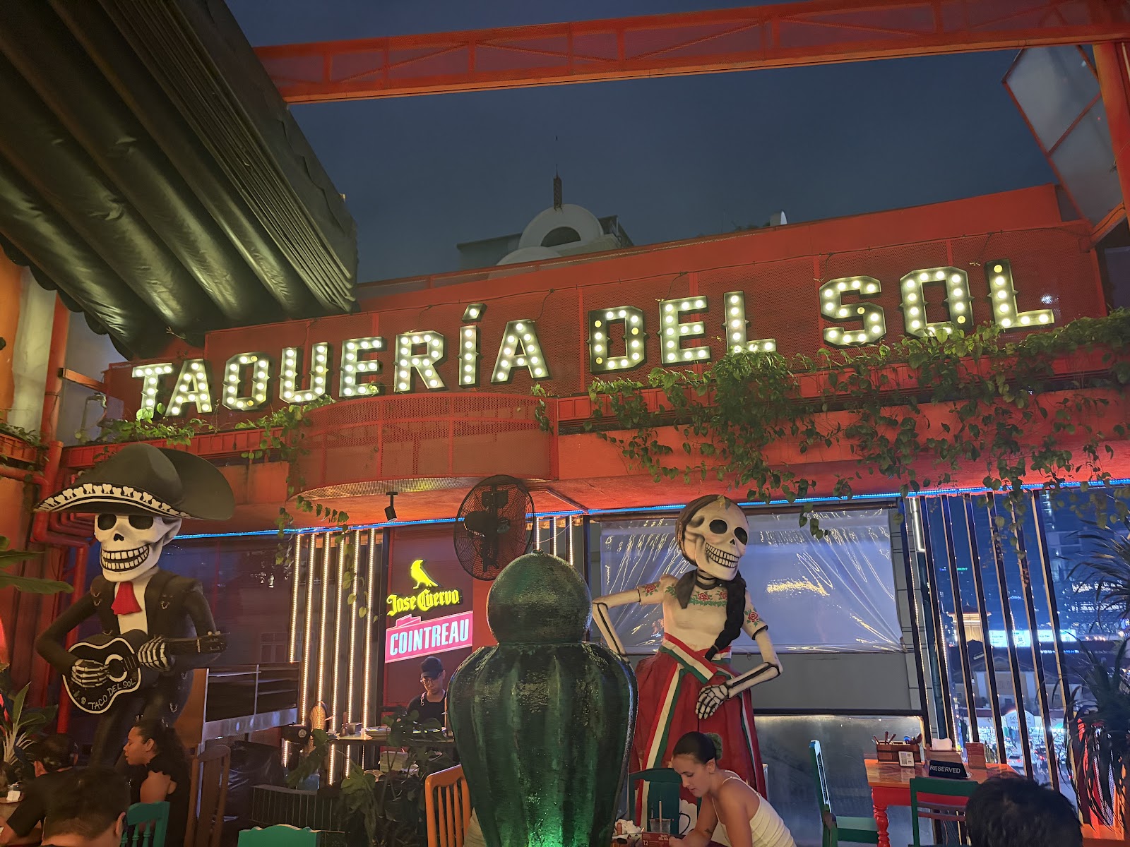Bảng hiệu “TAQUERÍA DEL SOL” bằng đèn marquee về đêm — mặt tiền quán