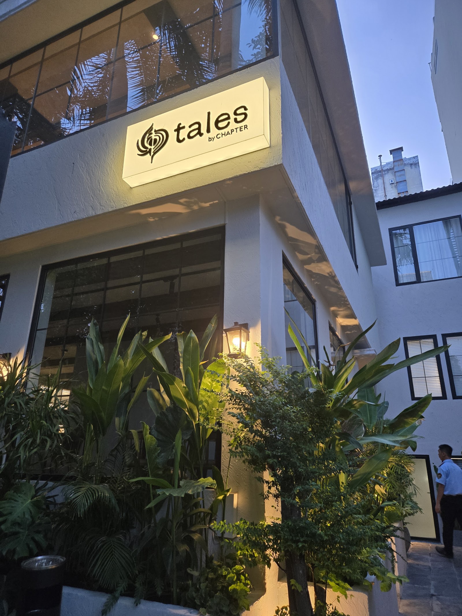 Tales by Chapter facade at dusk with the illuminated sign